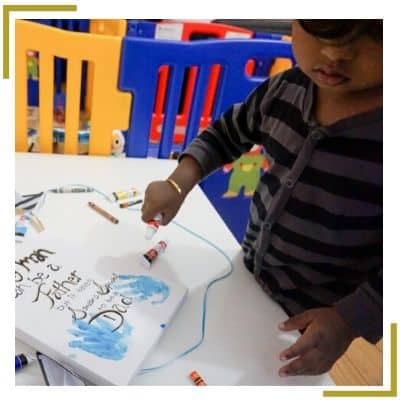 toddler making home made hand print canvas painting for Father's Day