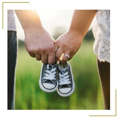 parents holding baby shoes to announce they are pregnant on social media