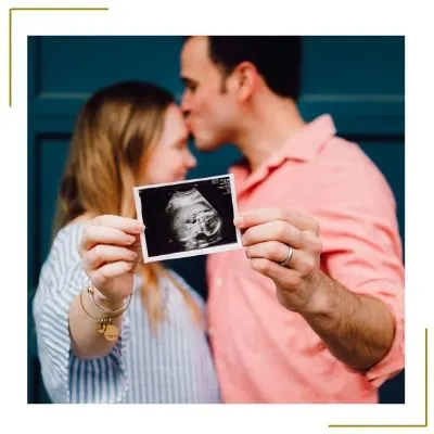 couple kissing holding ultrasound for baby announcement