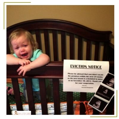 baby in crib crying with eviction notice sign for new baby arrival