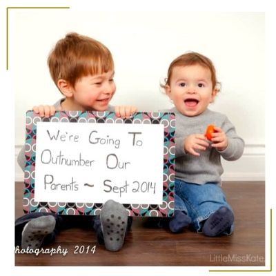 two toddler boys holding sign to announce new baby