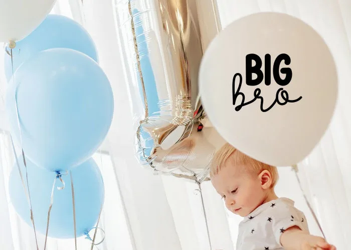 little boy holding balloon that says big bro for sibling pregnancy announcement