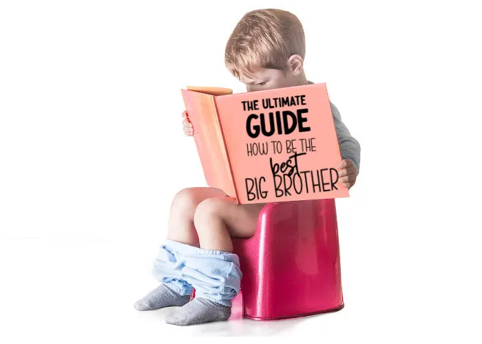 toddler boy sitting on potty reading ultimate guide to being a big brother book