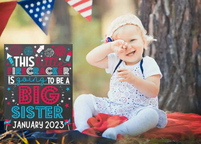 little girl sitting next to 4th of July pregnancy announcement big sister