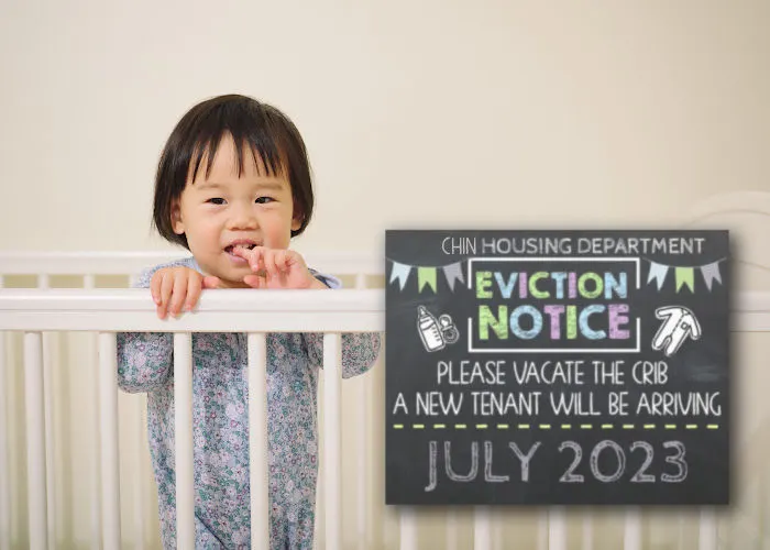 little Asian toddler in crib next to eviction notice pregnancy announcement sign