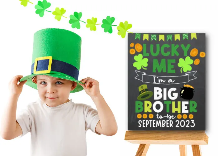 little boy wearing leprechaun hat standing next to St. Patrick's Day sibling announcement sign 