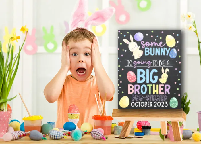 boy wearing bunny ears with surprised face standing next to Easter big brother announcement sign