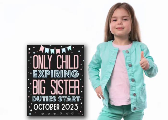 cute little girl doing thumbs up standing next to only child expiring pregnancy announcement sign