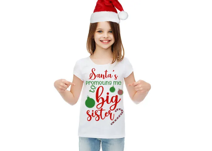 little girl wearing Christmas big sister announcement t-shirt