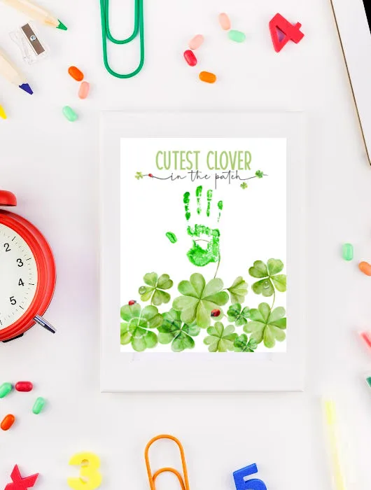 child's desk with framed St. Patrick's day handprint art that reads cutest clover in the patch