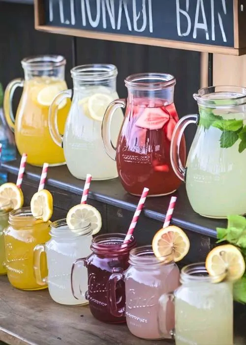 lemonade bar idea for homegrown baby shower theme featuring jugs of juice and mason jar drink cups
