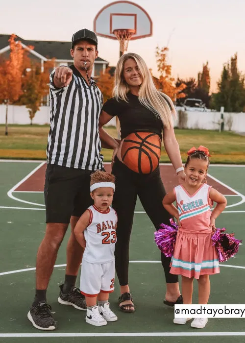 family pregnant halloween costumem idea. dad is dressed as a referee, mom is a basketball and the kids are basketball player and cheerleader
