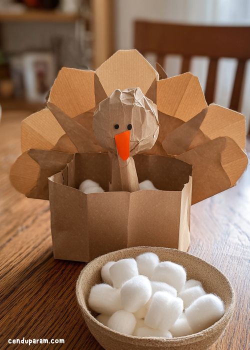 minute to win it games for thanksgiving. stuff the turkey game. paper turkey with cotton balls  in a bowl
