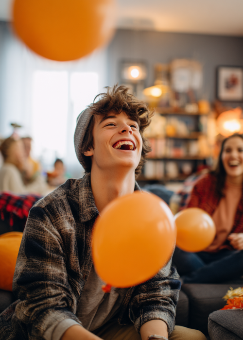 a young boy is playing a thanksgiving game with balloons and laughing 