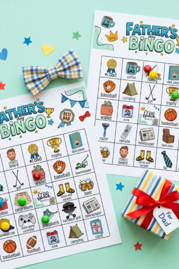 fun father's day bingo game cards on green flat lay image
